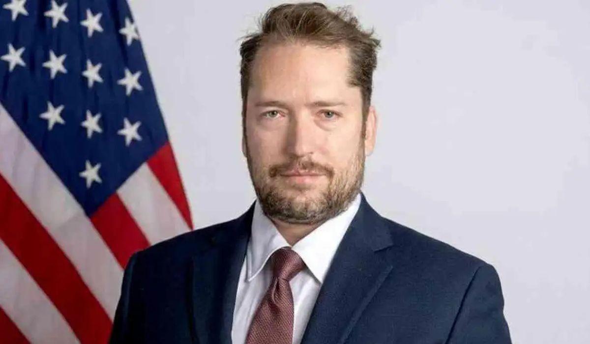 Image: https://reporterdobrasil.com/wp-content/uploads/2026/03/postiimg-69b2e12788c1d8008.jpg Darren Beattie assessor do governo dos Estados Unidos ligado ao presidente Donald TrumpFoto DivulgaoDepartamento de Estado dos EUAND mais